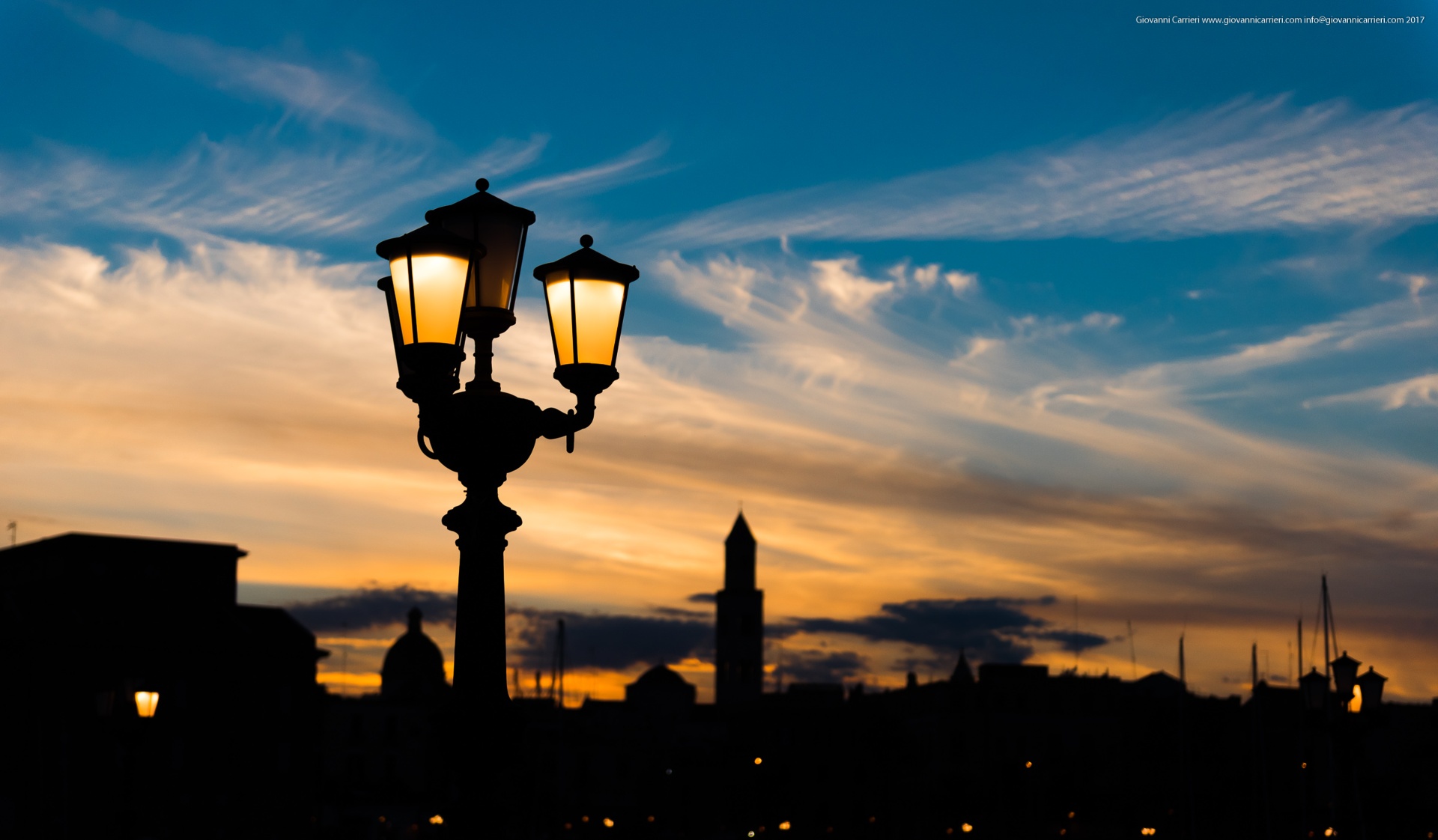 Sunset over Bari skyline with vintage lamp post